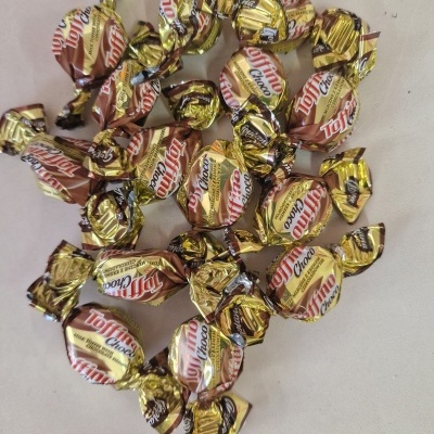 Vários bombons Toffino Choco embalados individualmente sobre superfície clara