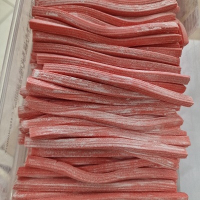 Bastões de doce rosa com pó branco em recipiente transparente