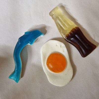 Gomas de mascar em formas de golfinho azul, ovo estrelado e garrafa de refrigerante