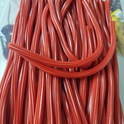 Doce vermelho em tubos flexíveis com riscas brancas dentro de caixa de plástico