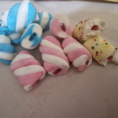 Gomas doces em espiral de cores azul/branco, rosa/branco e branco com granulados coloridos