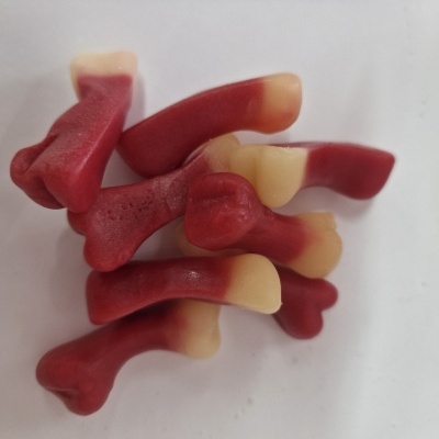 Gelatinosos em forma de ossos vermelhos e creme sobre fundo branco
