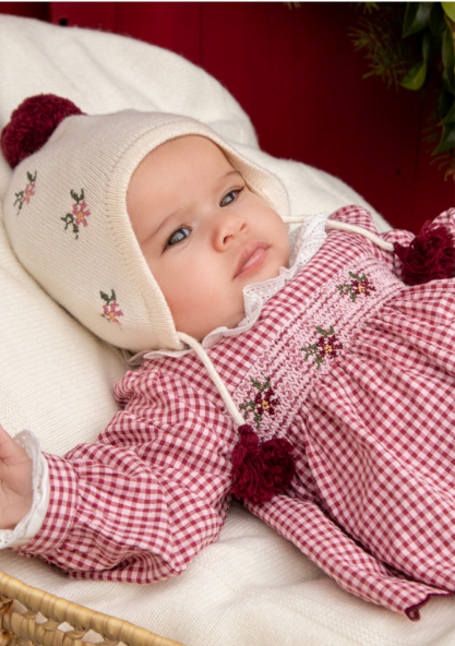 Conjunto Blusa Vichy e Calça Malha Bordeaux Dr. Kid | Grandma's Treat Bebé com vestido xadrez vermelho e branco e gorro creme com flores e pompons vermelhos