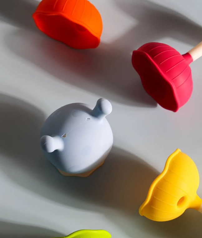 Mordedor Cogumelo Mimi Objetos de silicone coloridos com texturas variadas sobre fundo cinza ondulado