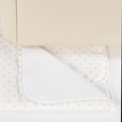 Toalha ou manta branca com padrão castanho claro junto a caixa bege