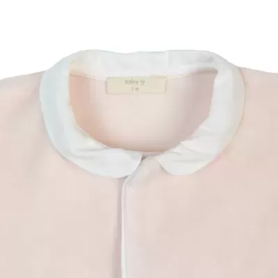 Body de bebé rosa claro com gola branca e etiqueta visível