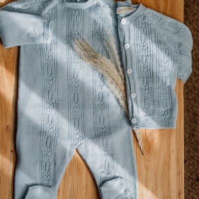 Roupa de bebé azul claro em malha com padrão de trança e etiquetas Wedoble
