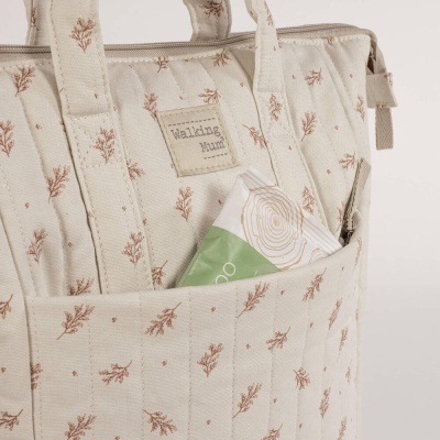 Mala bege com padrão de folhas e bolso frontal com embalagem