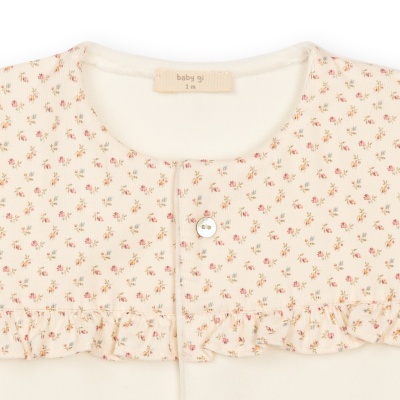 Blusa de bebé creme com padrão floral e gola com folhos