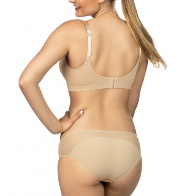 Mulher de costas com conjunto de lingerie bege, soutien e cuecas