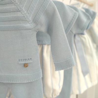 Conjunto bebê azul clara em malha com botão de madeira pendurado em cabides