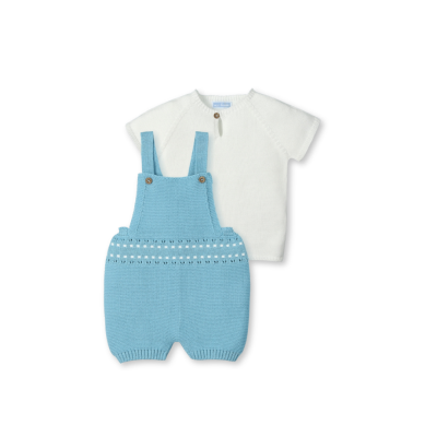 Conjunto de roupa para bebé com camisola branca e jardineiras azuis de malha.
