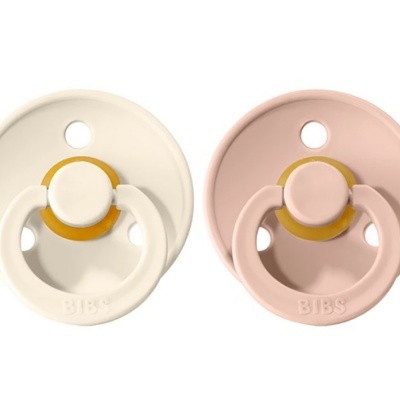 Duas chupetas BIBS, uma creme e outra rosa