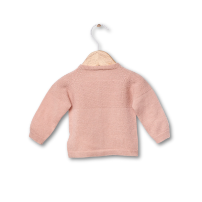 Camisola rosa de malha com padrão texturizado e gola alta pendurada em cabide de madeira