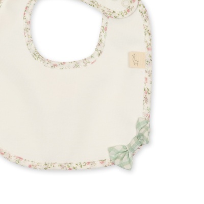 Babete branco com borda floral e laço xadrez verde.