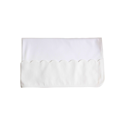 Toalha branca dobrada com padrão ondulado na parte inferior