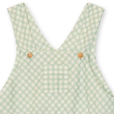 Macacão infantil verde claro xadrez com botões de madeira e bolso frontal