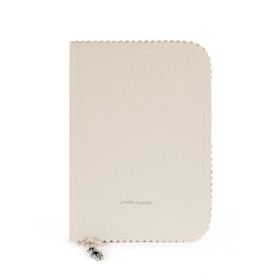 Capa de caderno bege com bordas decorativas e fecho com pendente