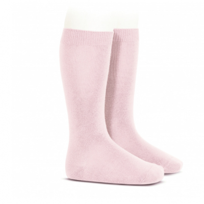 Meias compridas cor de rosa em tecido felpudo em suporte branco