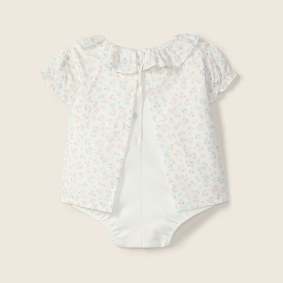 Body de bebé branco com padrão floral pastel e gola de babados