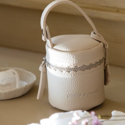 Bolsa pequena branca cilíndrica com alça e zíper numa superfície de madeira clara