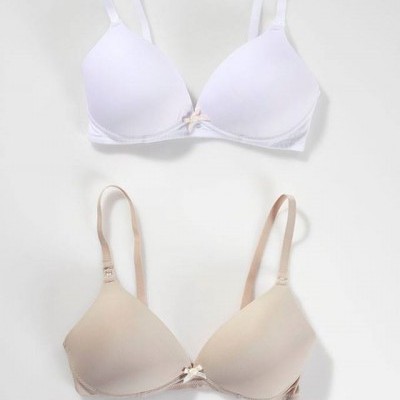 Dois soutiens, um branco e um bege, sobre fundo cinza.