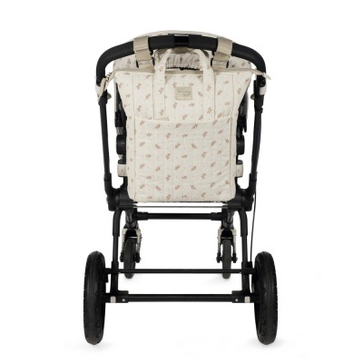 Carrinho de bebé preto com tecido bege e padrão floral visto de trás