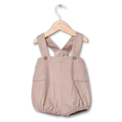 Roupa de bebé bege com botões em cabide de madeira