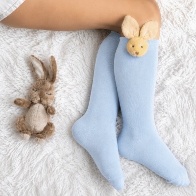 Meias azuis com peluche de coelho e brinquedo peluche coelho ao lado