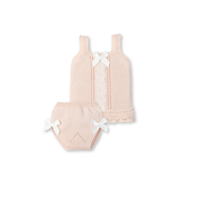 Conjunto de bebé em malha rosa clara com renda e laços brancos.