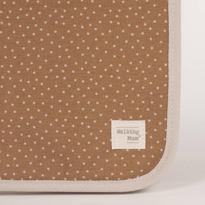 Tecido castanho com bolinhas brancas e etiqueta 'Walking Mum'