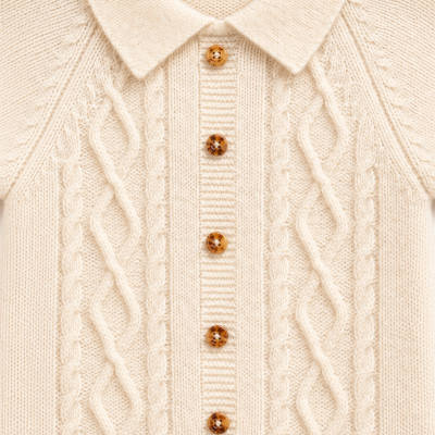 Camisola de malha creme com padrão trançado e botões castanhos