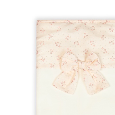 Capa de tecido creme com padrão floral e laço grande no centro