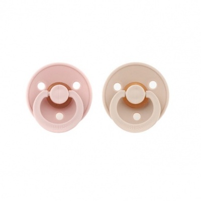 Dois chupetas de silicone rosa e bege em fundo branco