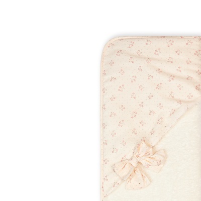 Detalhe de tecido bege com flores rosas e laços cor de rosa
