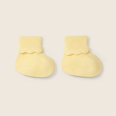 Meias amarelas tricotadas para bebé com bainha ondulada.