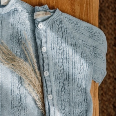 Conjunto de roupa de bebé azul clara de malha com botões brancos