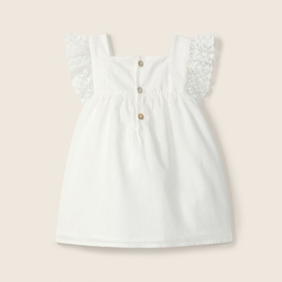 Blusa branca de criança com botões e mangas de renda