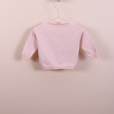 Camisola rosa clara para bebé pendurada