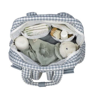 Mala de maternidade aberta com fraldas, escova, creme, biberão, miminho e chupeta dentro