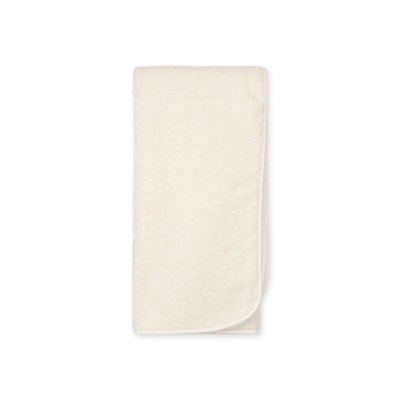 Toalha de banho creme dobrada sobre fundo branco