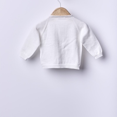 Camisola branca de malha para bebé pendurada num cabide