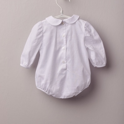 Body branco de bebé com mangas compridas e gola redonda pendurado num cabide