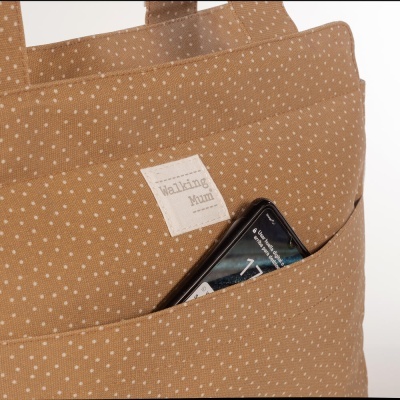 Mala castanho claro com pontos brancos e bolso com telemóvel