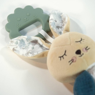 Brinquedo para bebé com cabeça de tecido e peça de silicone verde em forma de rosto de animal.