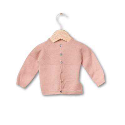 Casaco de malha infantil rosa pendurado em cabide