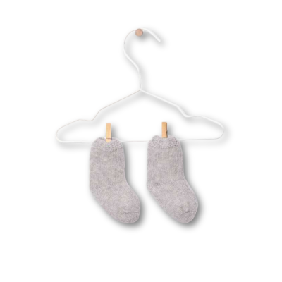 Meias cinza claro infantis penduradas num cabide branco com pregadores de madeira.
