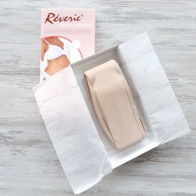 Cinta elástica bege em embalagem aberta e caixa cor-de-rosa com 'Rêverie Lingerie Maternal'