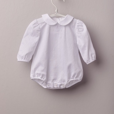 Babygrow branco de tecido liso com mangas compridas pendurado num cabide