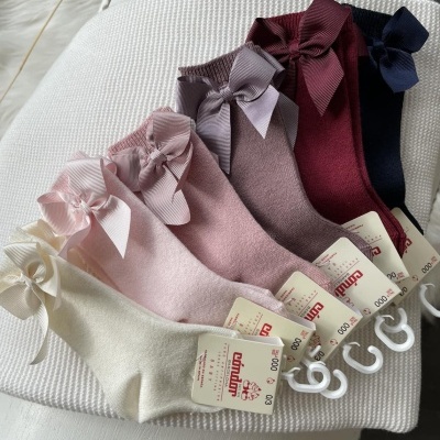 Cinco pares de meias infantis coloridas com laços e etiquetas da marca